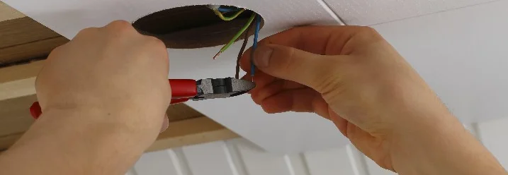 Person schneidet Kabel mit Zange